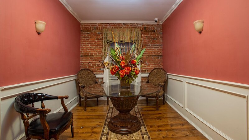 Hallway with salmon and brick walls with seating and flower decorations on table