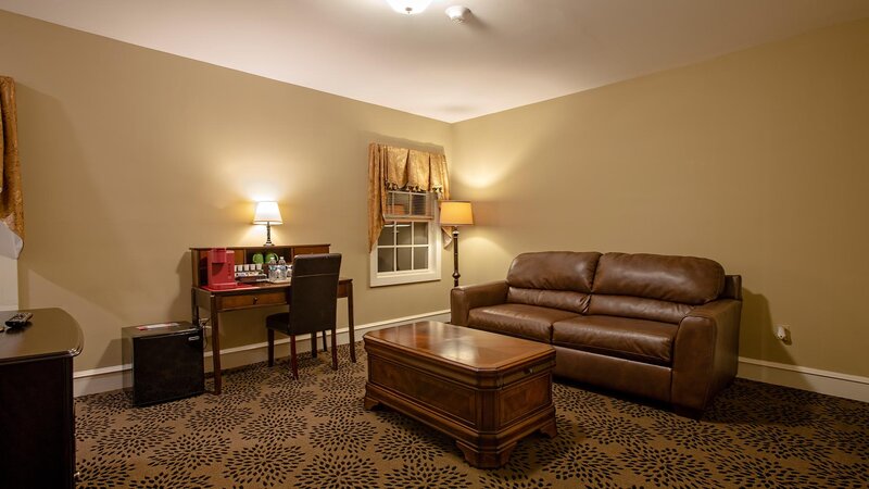 Living room with beige walls, brown leather couch and coffee table